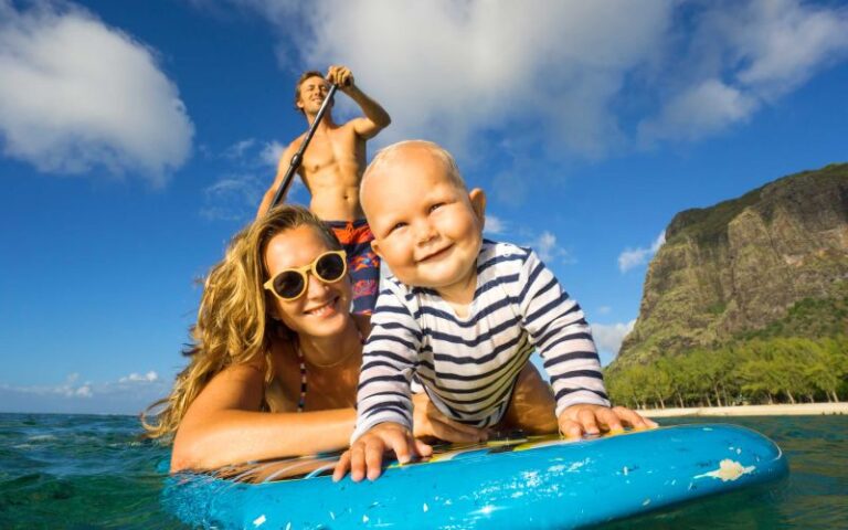 Família a praticar paddle numa praia tropical durante as férias