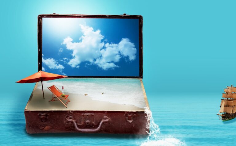 Mala de viagem aberta com uma praia, um chapéu de sol e uma espreguiçadeira, sobre o mar
